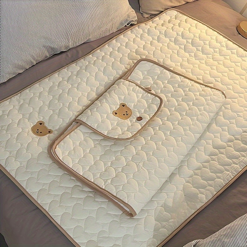 Portable changing mat with cream bear pattern, foldable, breathable polyester, adjustable strap, ideal for short trips.